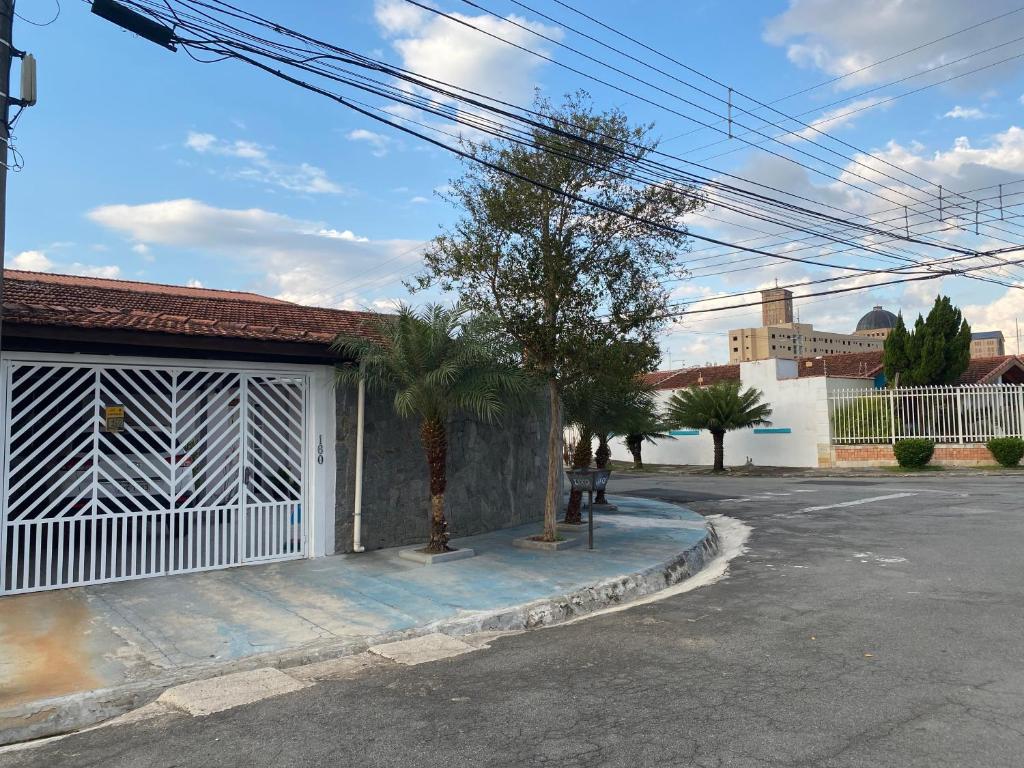 a building with a white garage door with a palm tree at CASA FAMILIAR “SANTA PAZ” in Aparecida