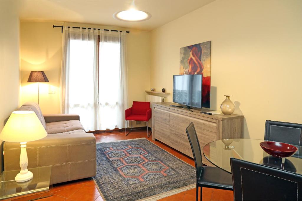 - un salon avec un canapé et une télévision dans l'établissement Claudio Appartamenti, à Bardolino