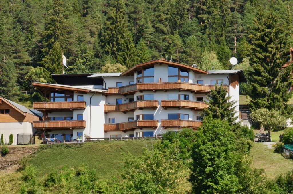 ein großes Gebäude auf einem Hügel mit Bäumen in der Unterkunft Appartement Seejoch in Seefeld in Tirol