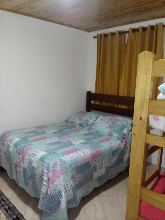 een kleine slaapkamer met een bed en een ladder bij Casa Eudileia in Campos do Jordão