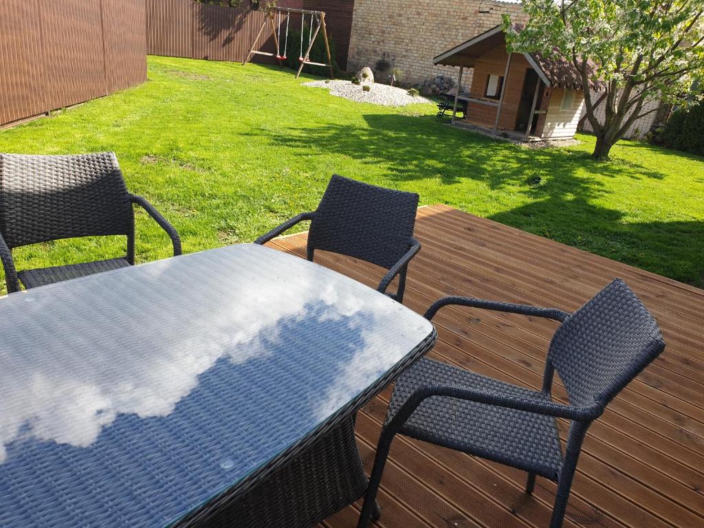 una mesa y sillas en una terraza de madera en Svečių namai Kamile en Šiauliai