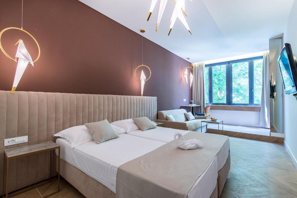a bedroom with a large bed and a couch at Bošket Luxury Rooms in Split