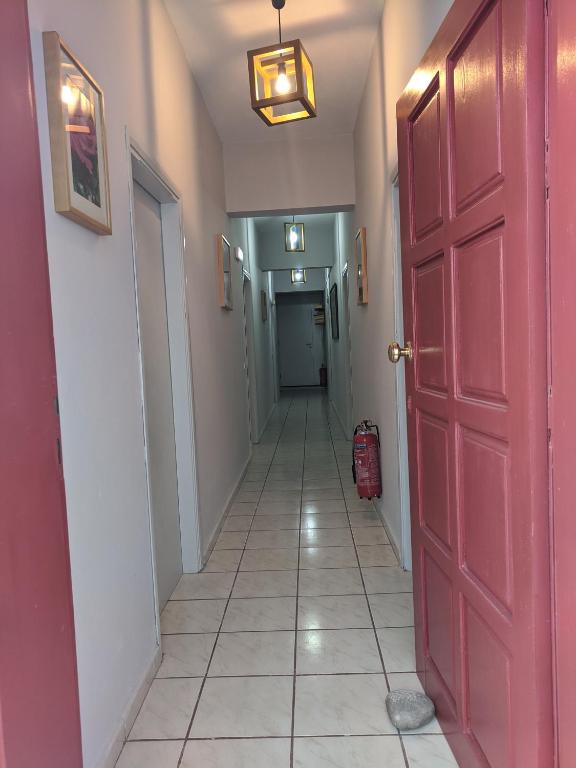 a hallway with a red door and a tile floor at Pension Irene in Sougia