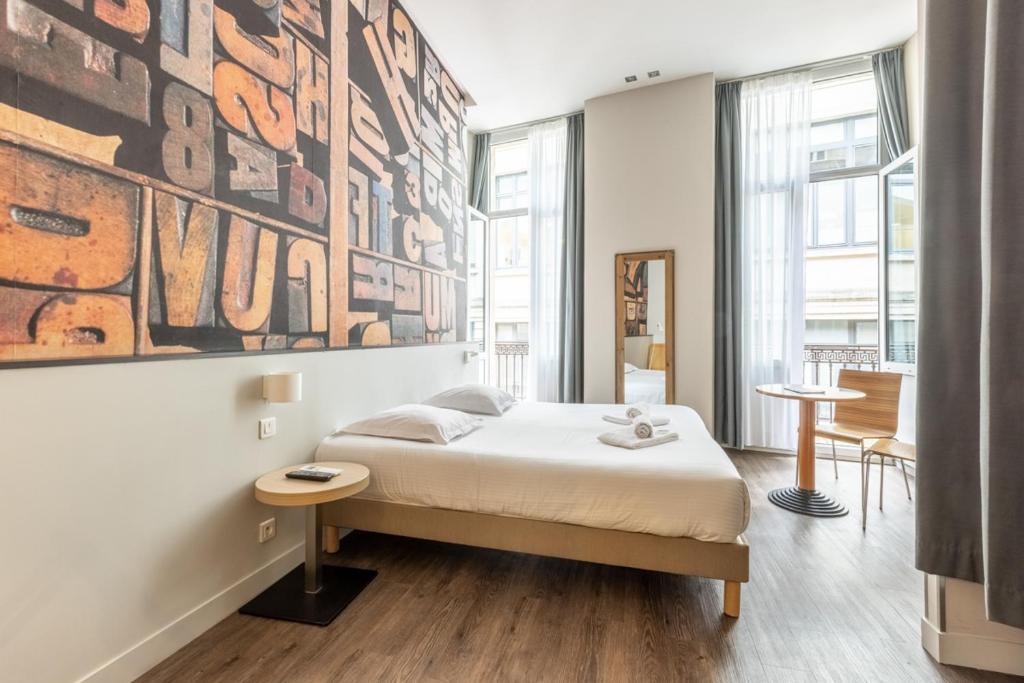 מיטה או מיטות בחדר ב-Hotel de la Presse Bordeaux Centre