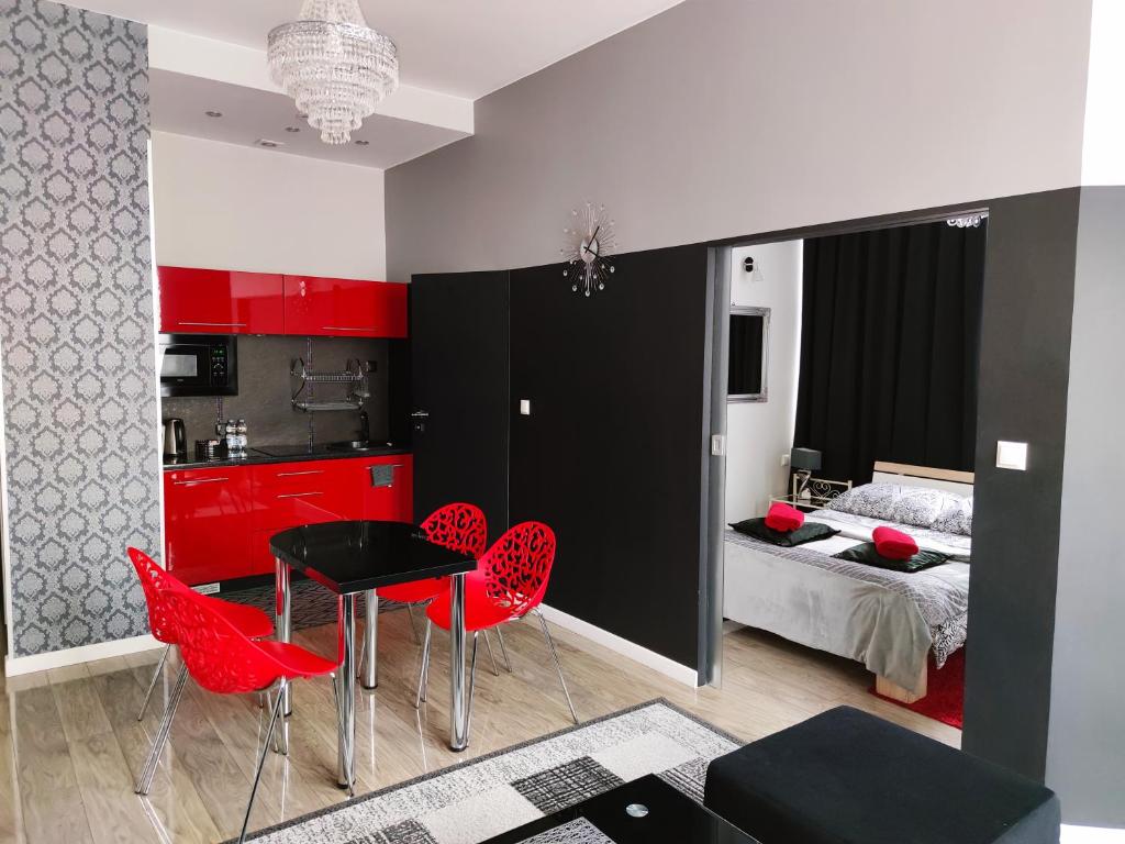 Habitación con sillas rojas, mesa negra y cama en Apartamenty Centrum Krawiecka, en Zielona Góra