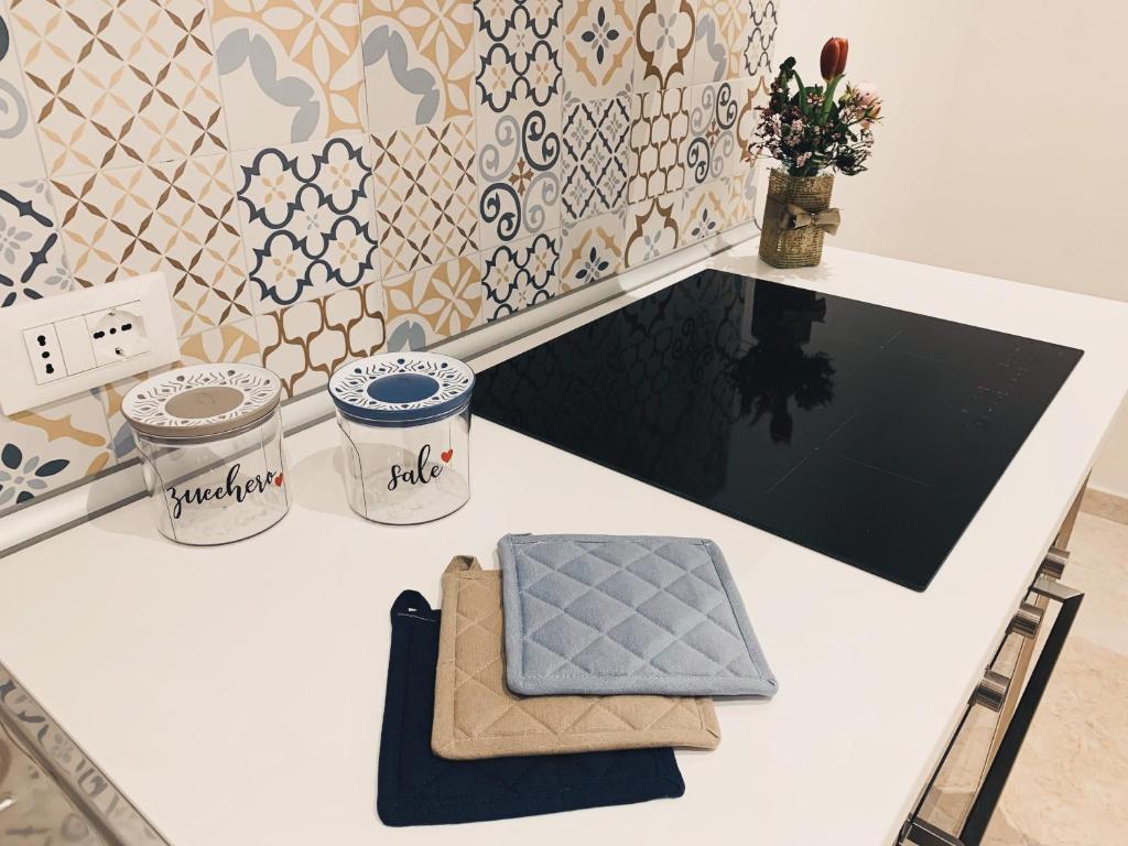 a white counter with a table with a pillow on it at Talos Apartments in San Vito lo Capo