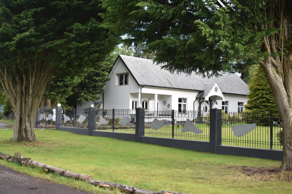 una casa blanca con una valla delante en The Retreat Tranquil Countryside Apartment en Larkhall