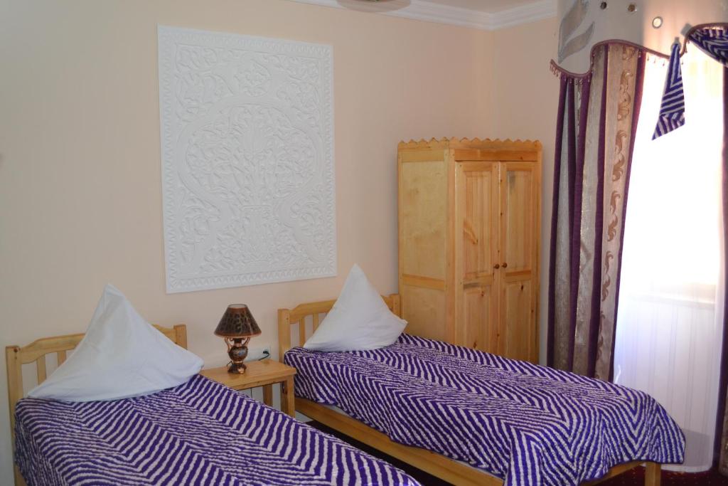 een slaapkamer met twee bedden en een raam bij HOTEL KALA KHIVA in Khiva