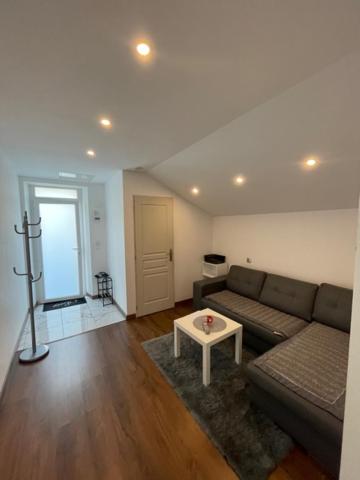 a living room with a couch and a table at Studio privée Vesoul -Wifi,TV,Clim in Vesoul