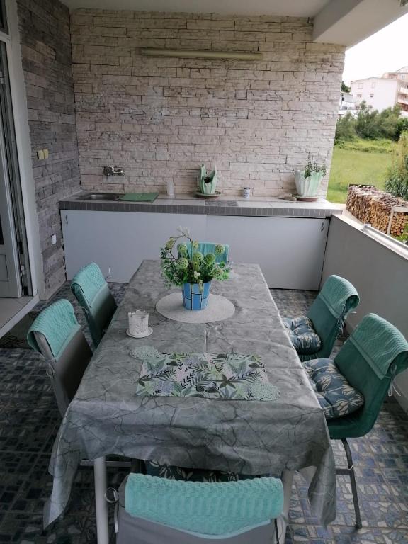 a table and chairs on a patio at Big Blue - Xenija (Veliko Plavetnilo - Ksenija) in Metajna