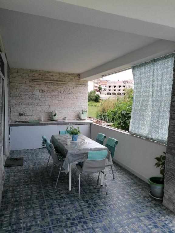 a patio with a table and chairs on a balcony at Big Blue - Xenija (Veliko Plavetnilo - Ksenija) in Metajna