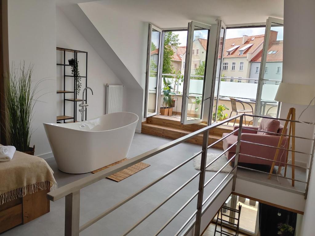 ein Badezimmer mit einer Badewanne auf einer Glasscheibe in der Unterkunft B&N Apartments in Mrągowo