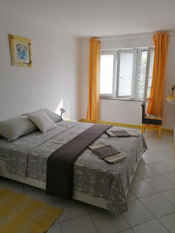 a bedroom with a large bed and a window at Big Blue - Xenija (Veliko Plavetnilo - Ksenija) in Metajna