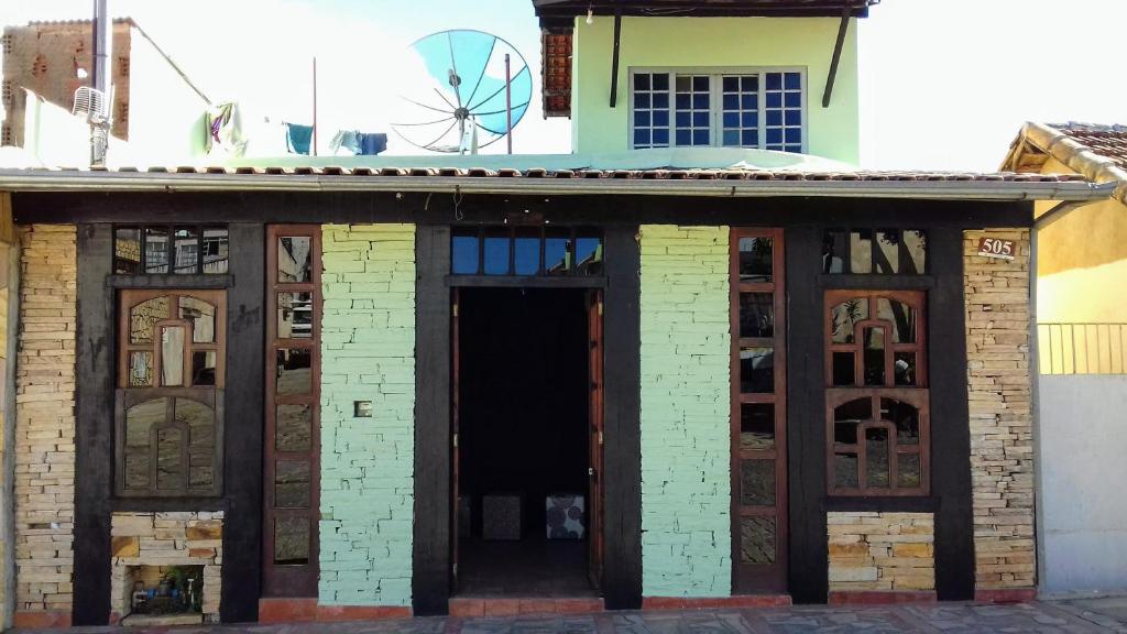 Palácio do Sol Hostel Pousada في ساو ثومي داس ليتراس: مبنى من الطوب القديم مع باب ونوافذ