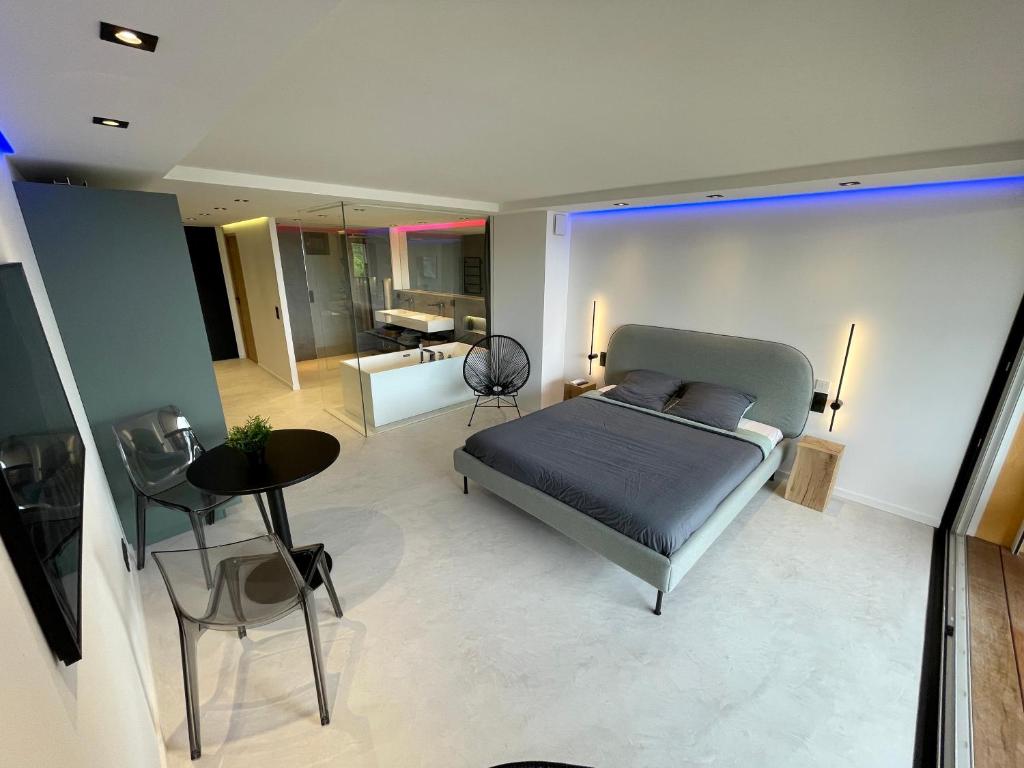 a bedroom with a bed and a living room at Appartement neuf climatisé - vue mer Saint-Tropez - 50m plage et port - piscine in Gassin