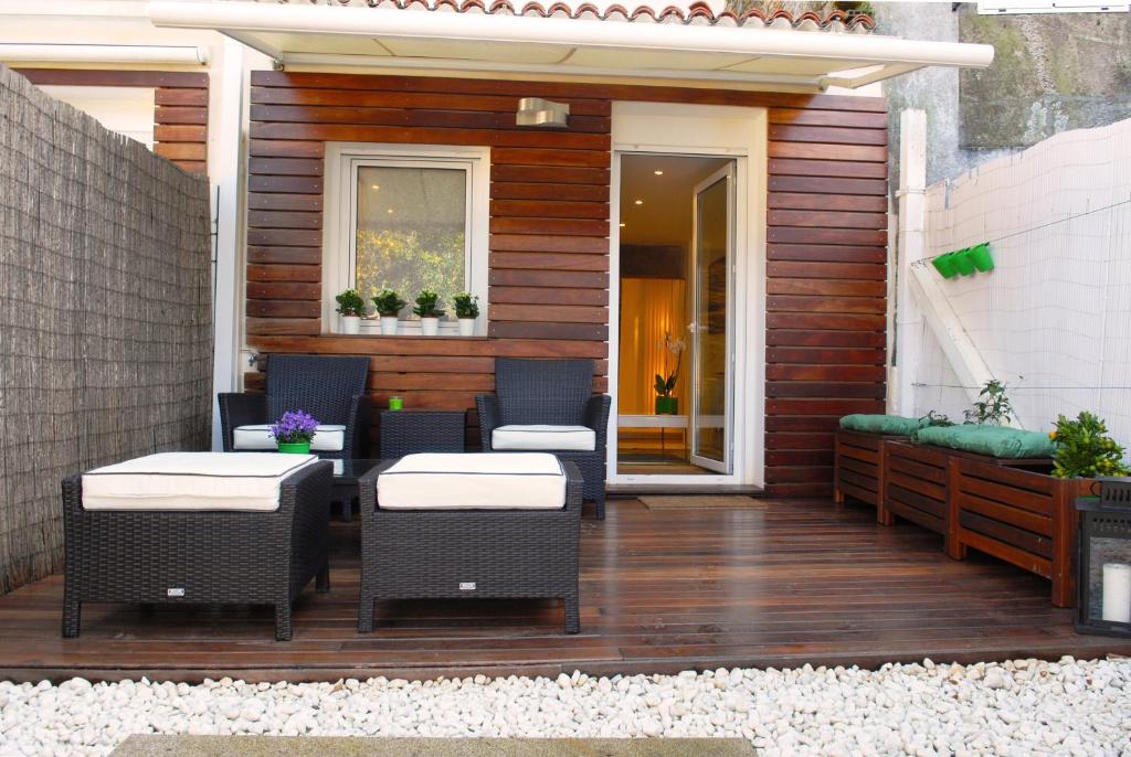 a patio with chairs and tables on a wooden deck at Green Home in Santiago de Compostela