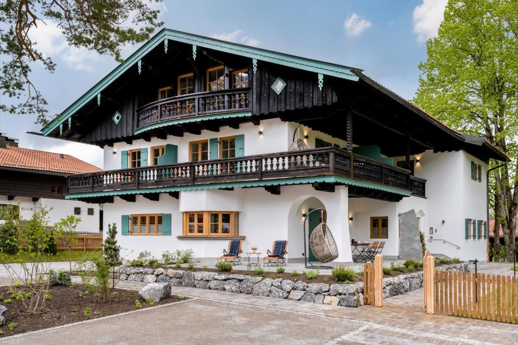 duży biały dom z balkonem w obiekcie Alperie Ferienhaus w mieście Schliersee