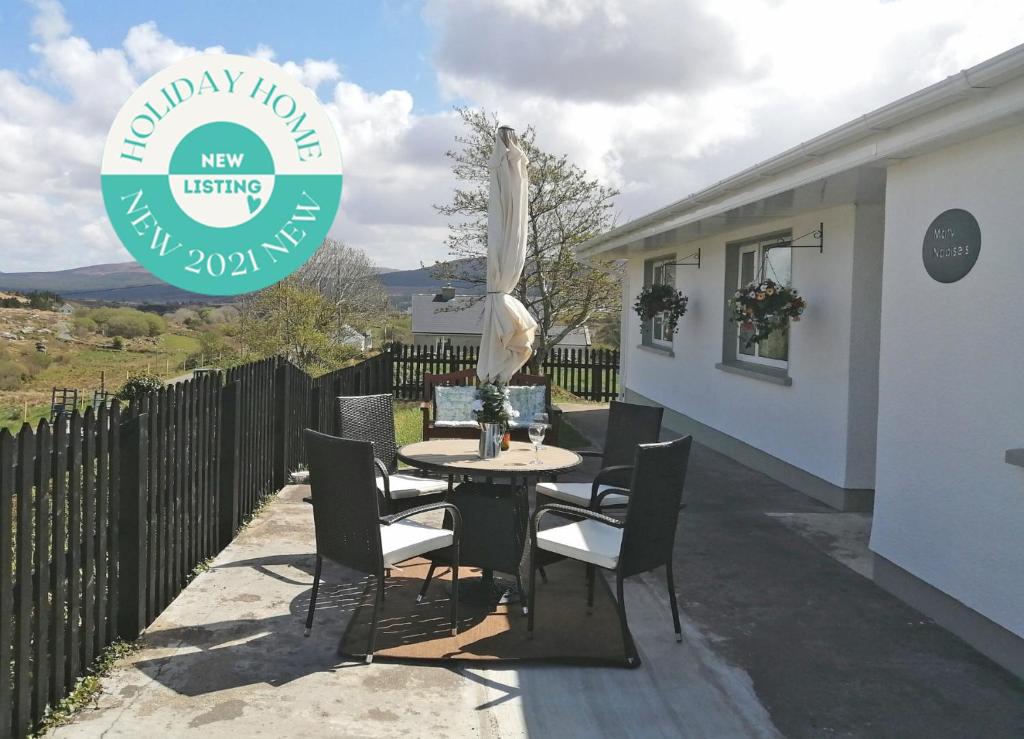 una mesa y sillas en el patio de una casa en Mary Naoise Holiday Home en Lettermacaward