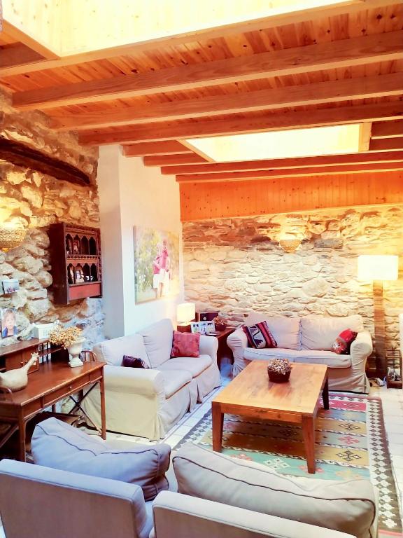 ein Wohnzimmer mit Sofas und einer Steinwand in der Unterkunft O Recanto do Atlantico in Viveiro