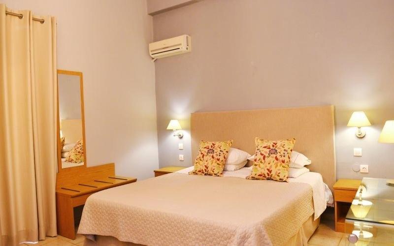 - une chambre d'hôtel avec un lit et un miroir dans l'établissement Fiorella Sea View, à Megali Ammos