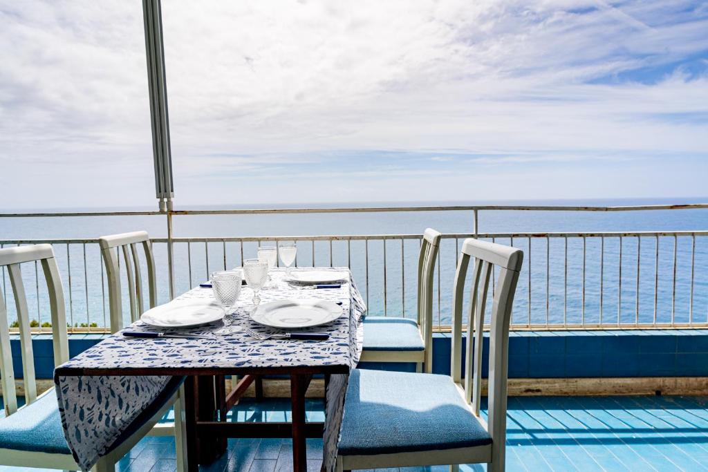 uma mesa numa varanda com vista para o oceano em Appartamento vista mare con due camere - Two-bedroom apartment with Sea View em Sanremo