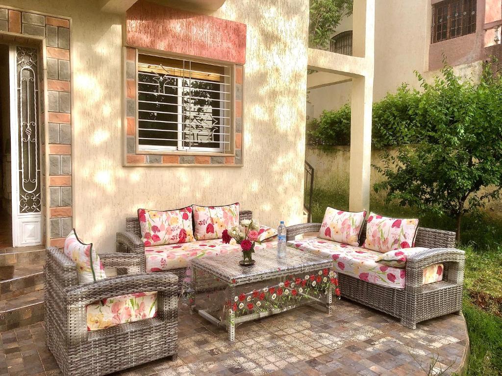 a patio with two wicker couches and a table at Villa ain soltan in Imouzzer Kandar