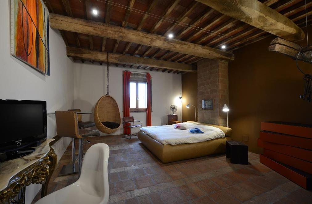 a bedroom with a bed and a tv in a room at Morelliana4Rooms in Scansano