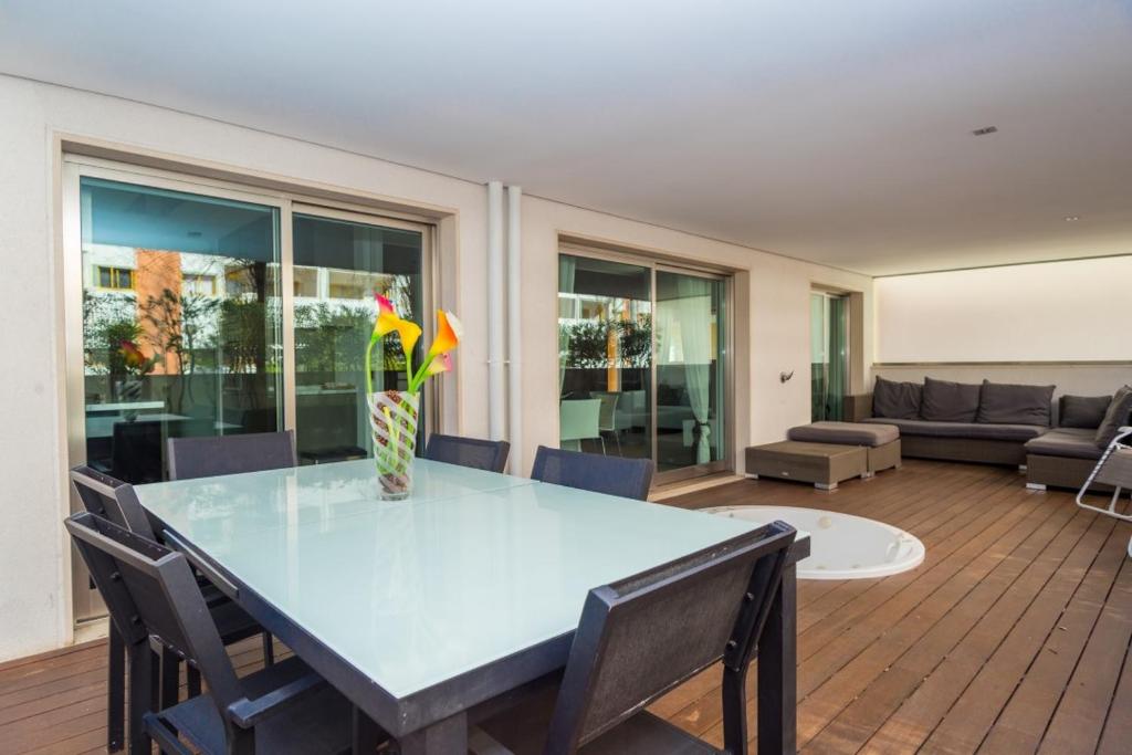 a table with chairs and a vase with a flower on it at Praia da Rocha Edifício Foz Palace t2 in Portimão