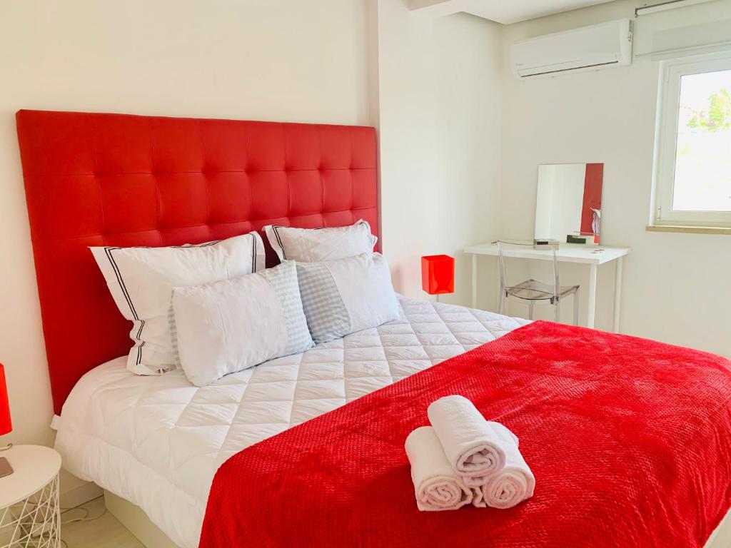 a bedroom with a red bed with two towels on it at Entire apartment in Lisbon plus Car in Lisbon