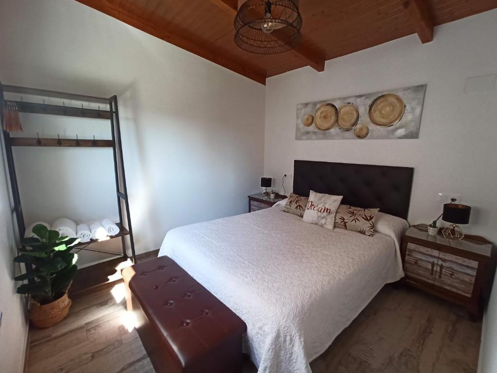 1 dormitorio con cama blanca y espejo en APARTAMENTO DO JOSÉ, en Pantón