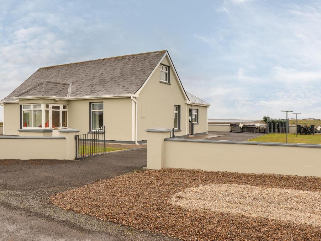 a white house with a black roof at Sea View Lodge in Mullagh