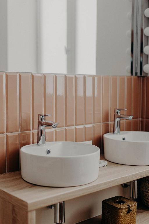 a bathroom with two sinks on a wooden counter at Hôtel PALMITO in Biarritz