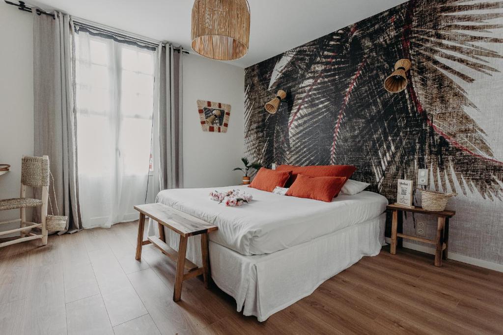 a bedroom with a bed and a mural on the wall at Hôtel PALMITO in Biarritz