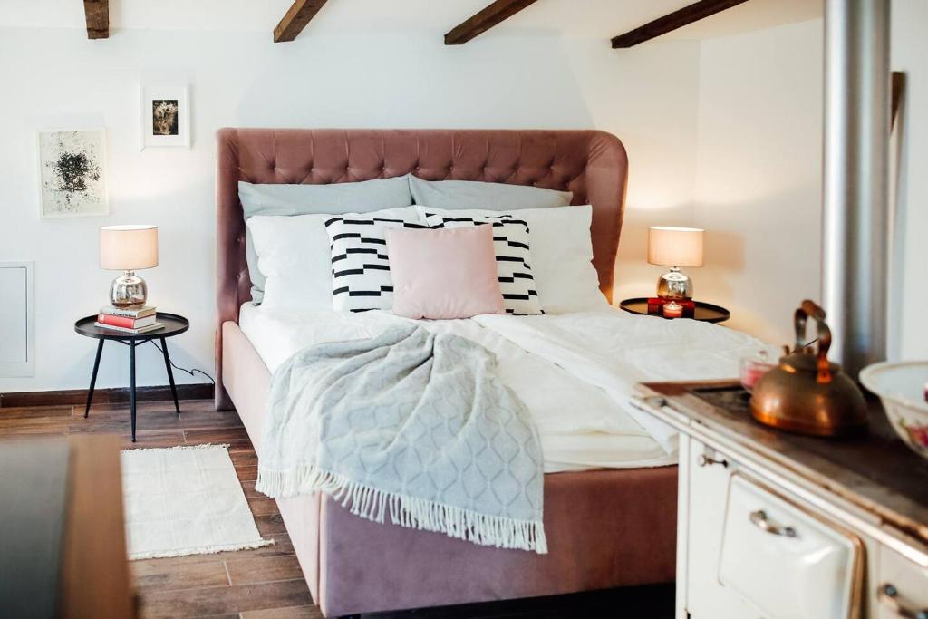 a bedroom with a large bed with a pink pillow at Apartment Aussee- Atelier Salzherrenhof- Küche, WLAN, Netflix in Bad Aussee