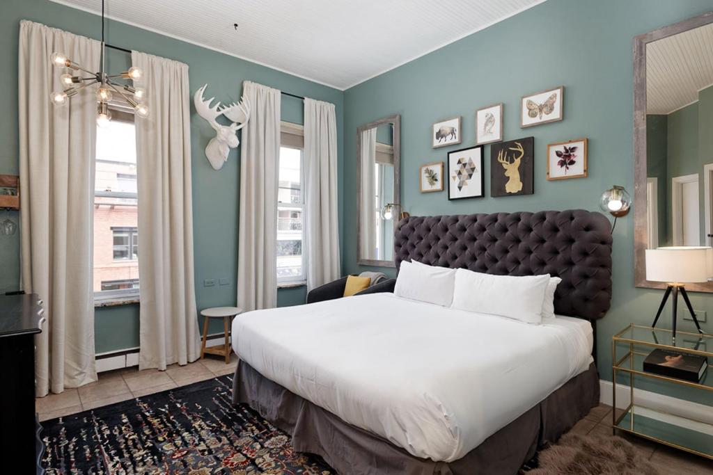 a bedroom with a large white bed and blue walls at Independence Square Unit 206 in Aspen