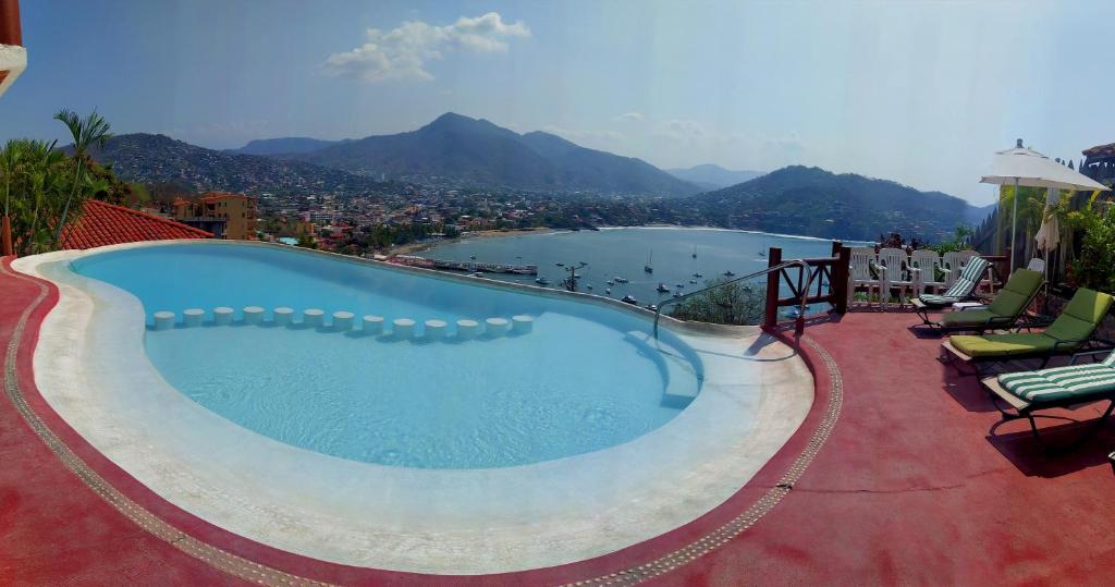 una piscina con vistas a un cuerpo de agua en Villas El Morro, en Zihuatanejo