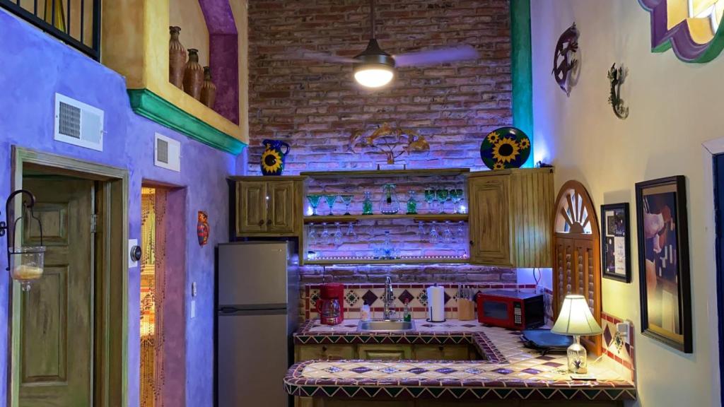 een keuken met een bar met een toonbank en een koelkast bij Loft with rooftop deck in the Malecon - Unit #206 in Puerto Peñasco