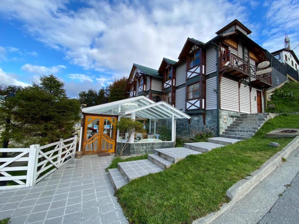 a large wooden house with a white fence at Hostería Patagonia Jarke in Ushuaia