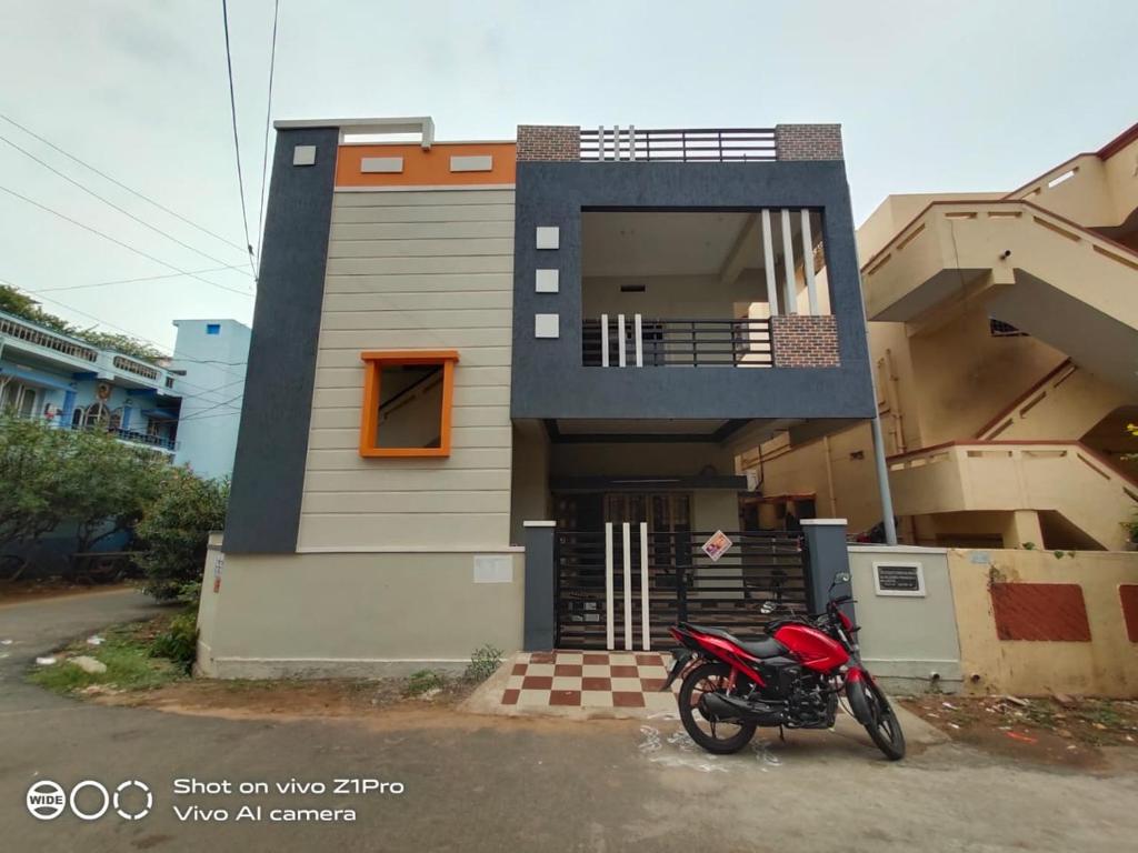Vizag homestay guest house في فيساخاباتنام: دراجة نارية حمراء متوقفة أمام منزل