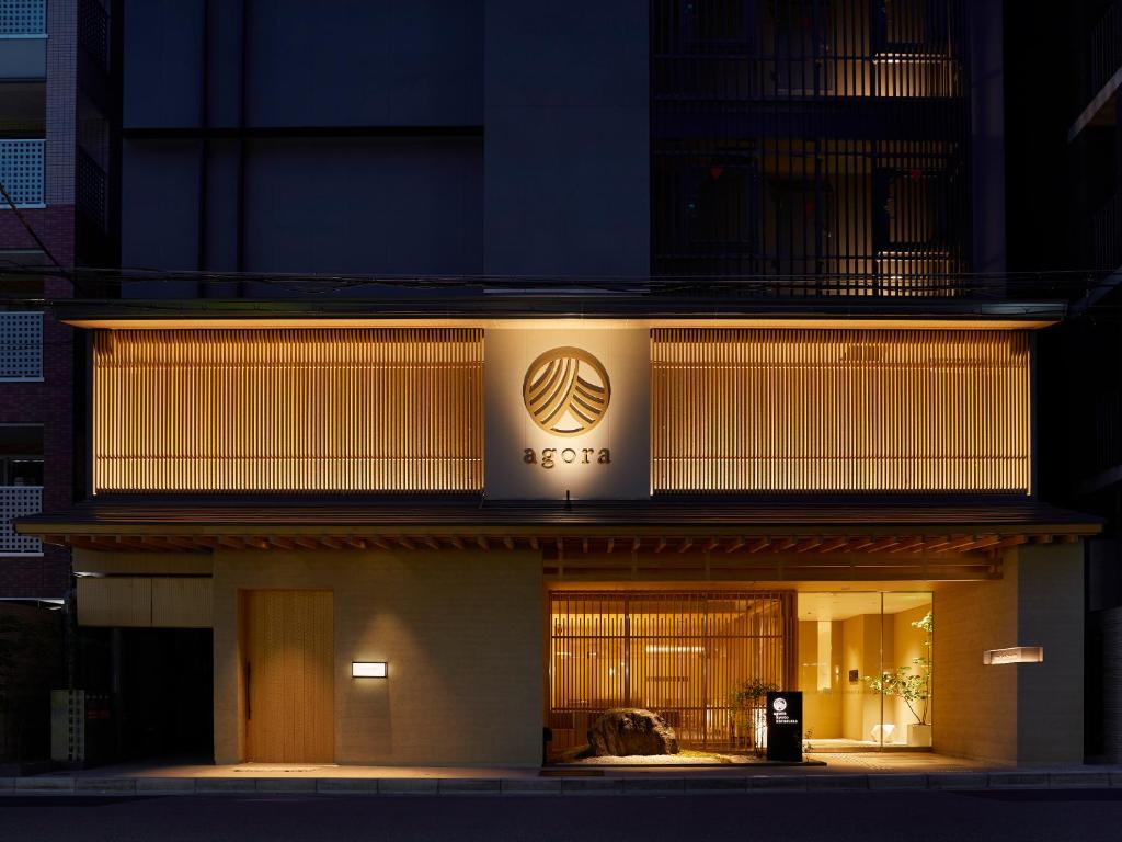 un edificio con un cartello sopra la notte di Agora Kyoto Karasuma a Kyoto