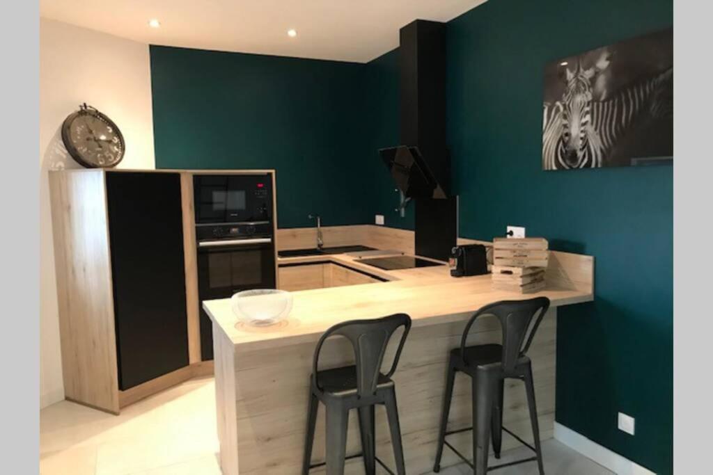 a kitchen with a counter and two stools at a kitchen island at Bourg superbe appart avec vue magnifique in Bourg-sur-Gironde