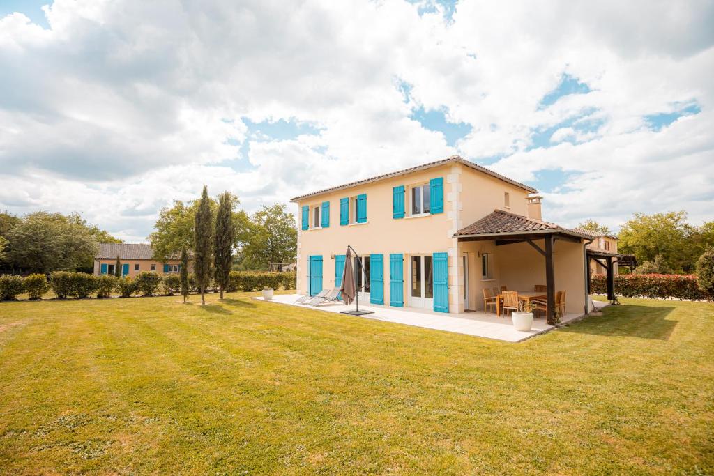 ein Haus mit blauen Fensterläden und einem großen Hof in der Unterkunft Les Forges Villas - 5 room villa for 8 people in Vasles