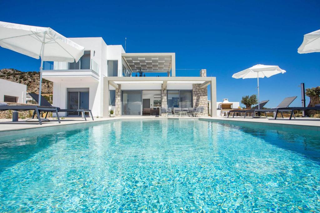 a swimming pool in front of a villa at Your House In Rhodes in Afantou