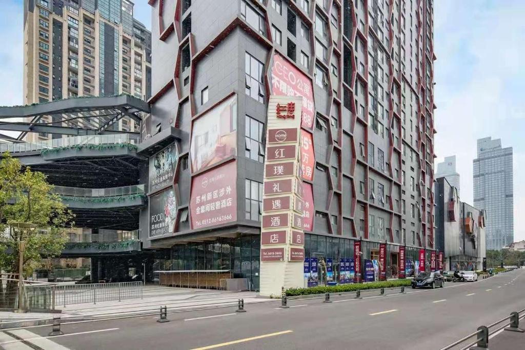 um edifício com placas no lado de uma rua em Home Plus Hotel em Suzhou