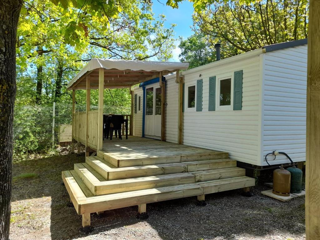 uma casa com um alpendre e escadas para uma cabana em Camping le Chêne em Tallard