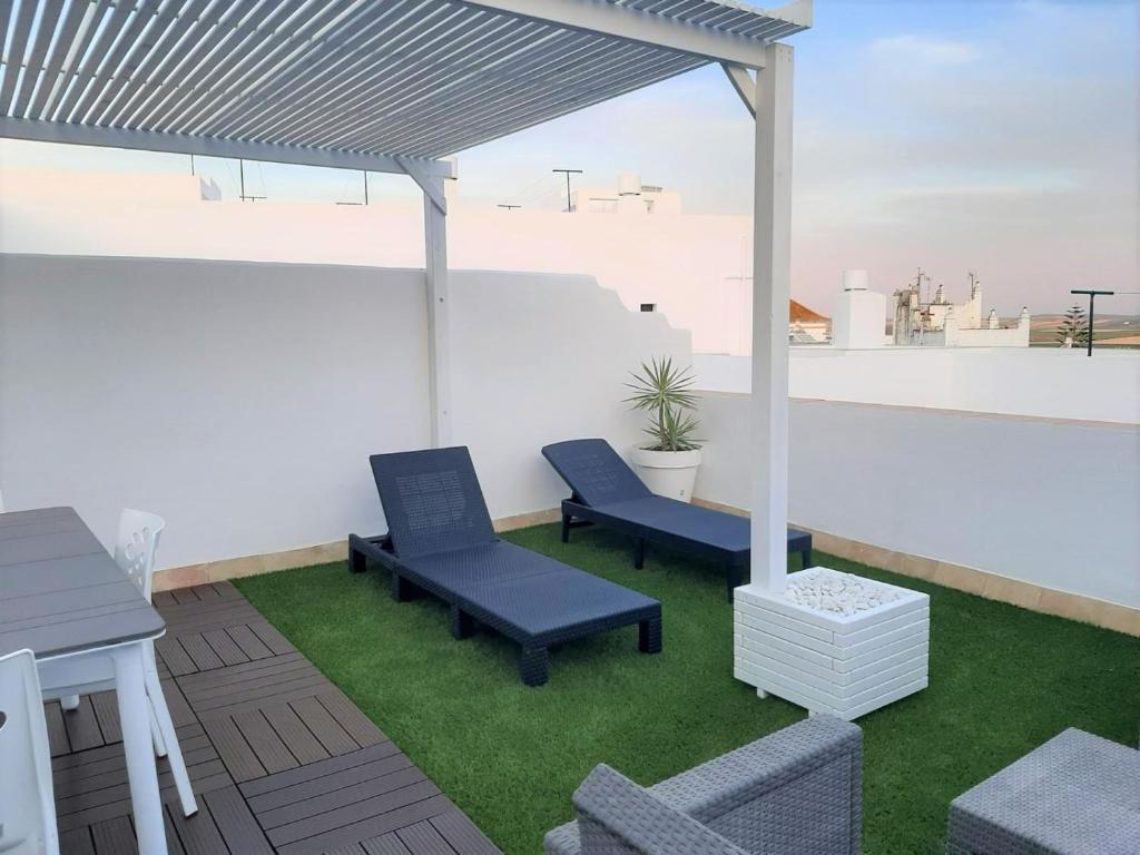 een patio met twee blauwe stoelen op een dak bij La Tahona de Max&jan in Conil de la Frontera