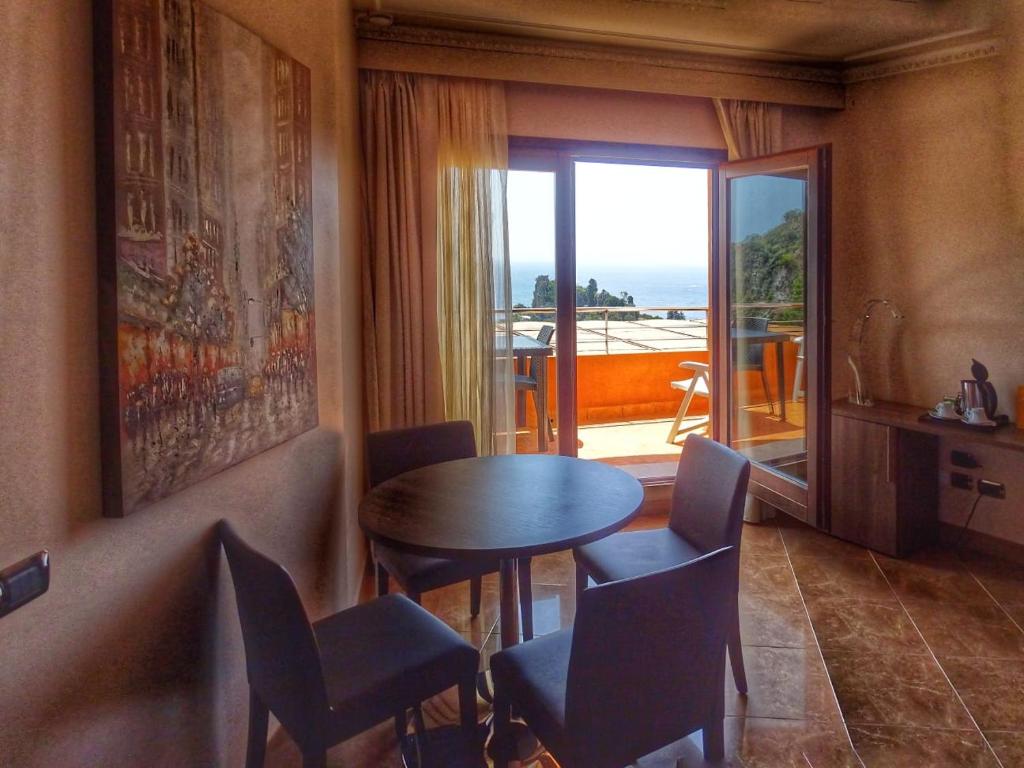 a room with a table and chairs and a balcony at Taormina Panoramic Hotel in Taormina