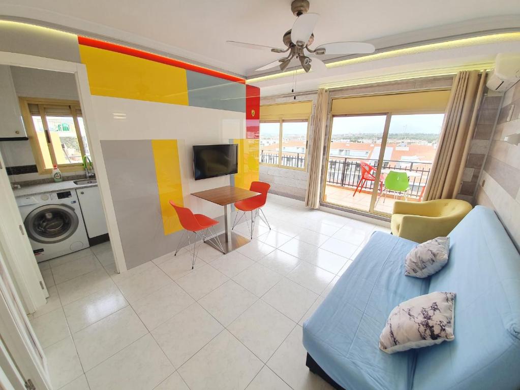 a living room with a blue bed and a kitchen at Apartamento en Salou con las vistas al Port Aventura in Salou