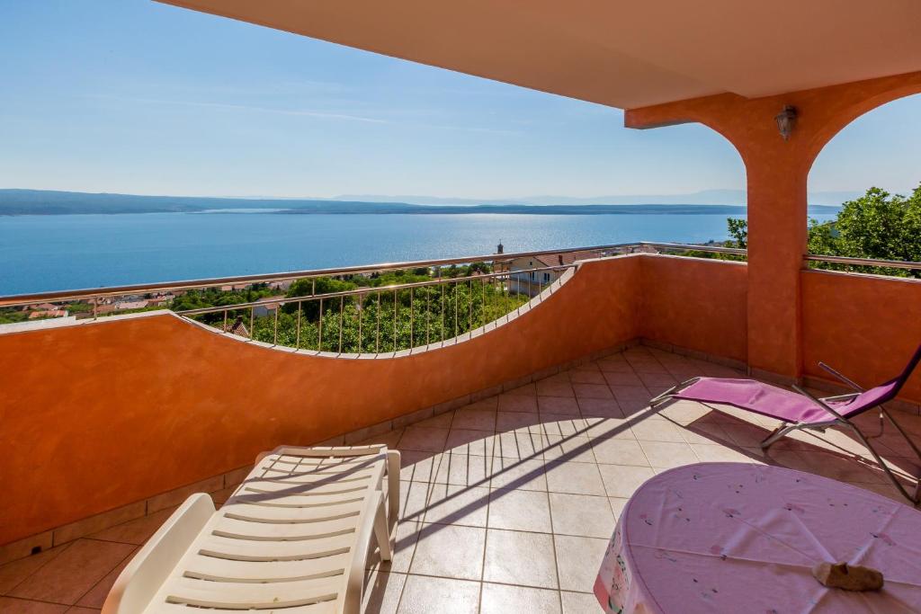 einen Balkon mit Stühlen und Blick auf das Wasser in der Unterkunft Apartmani Rino in Dramalj