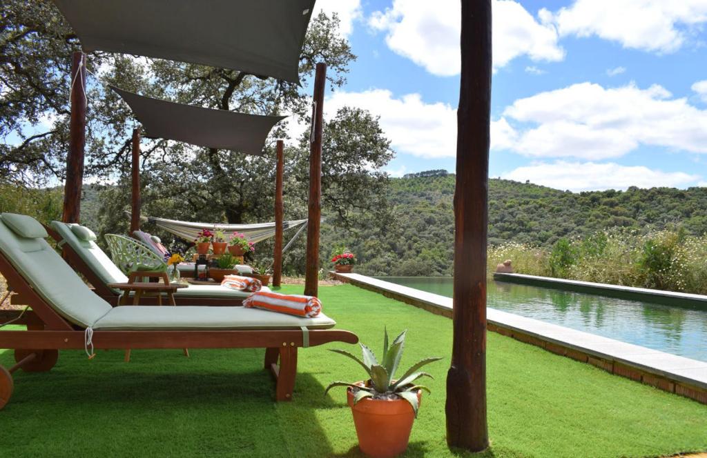 un patio con hamaca y vistas al agua en Finca Bravo, en Cortegana